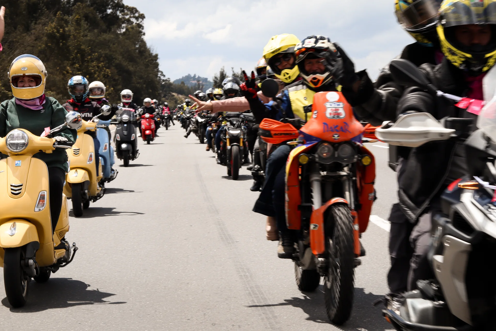 La caravana de La Ruta Rosa 2025 avanza por la carretera, con motocicletas de diferentes marcas.